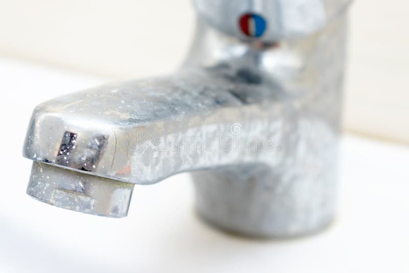 Calcified faucet covered in white scale